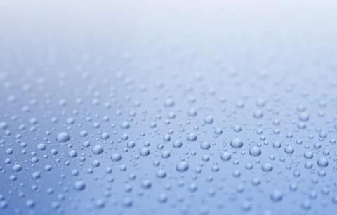 Clear water drops on gradient light blue background. Shallow depth of field. Stock Photos
