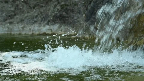 Clear water is falling into a natural pool with green water (slow motion) Stock Footage 211761218