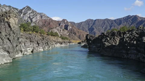Clear water of fast river, high mountain peaks, blue sky and green trees Stock Footage 194724631