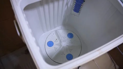 Clear Water Filling Empty Top-Loading Washing Machine Tub with Blue Pulsator Stock Footage 322718098
