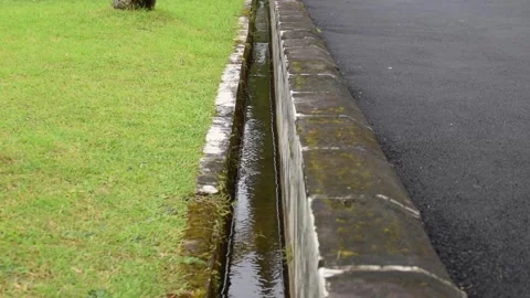Clear water flowing in a gutter near a hotel street and garden in West Java Stock Footage 312806438