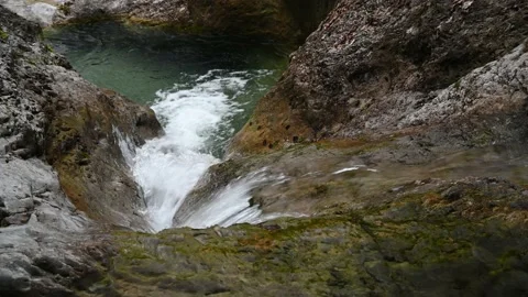 Clear water flowing over rocks into a natural pool 스톡 동영상 211467565