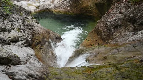 Clear water flowing over rocks into a pool Stock Footage 211467618