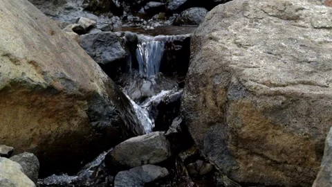 Clear water flows between large rocks Stock Footage 280379049