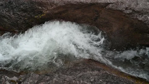 Clear water flows between rocks from a mountain stream Video stock 211454434
