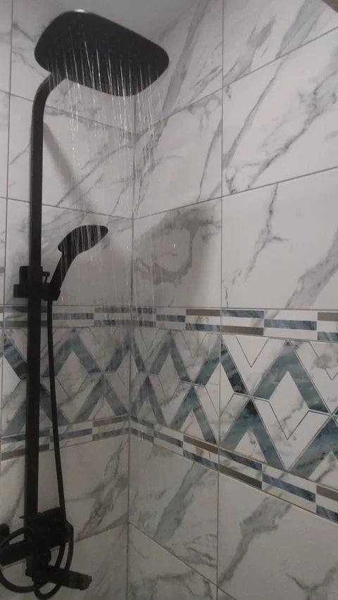 Clear water flows from a black rectangular shower head in the bathroom Stockbeeldmateriaal 318321863