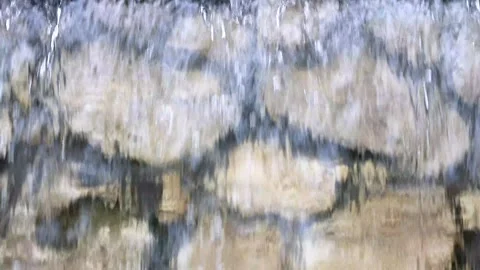 Clear water flows down a lip stone wall Stock Footage 310521373