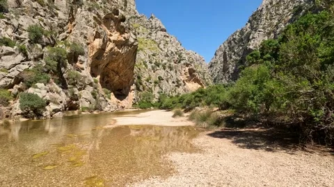 Clear water flows gently through rocky canyon on Mallorca island, Spain Stock Footage 330803783