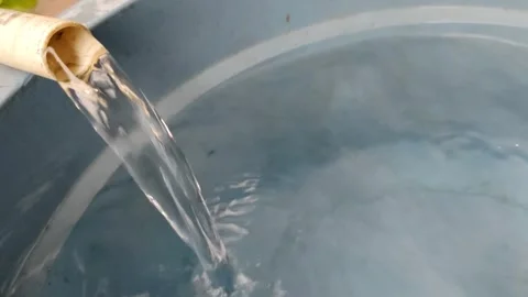 Clear water flows gracefully from the PVC pipe into the basin, creating ripples Stock Footage 304056273