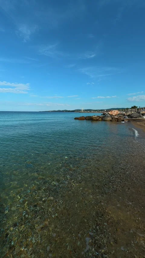 Clear water gently washes sandy shore. Nikiti, Greece. Vertical 스톡 동영상 339025834
