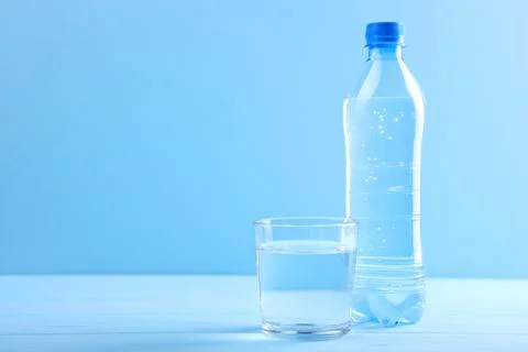 Clear water in a glass and bottle on the table Stock Photos