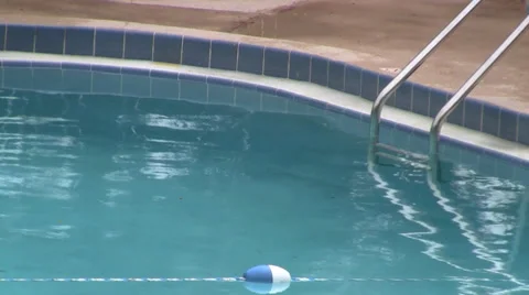 Clear water laps in a pool on a windy day in tropics featuring a ladder Video stock 36622860