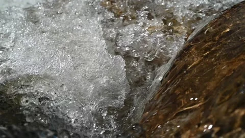 Clear water from a mountain stream creates swirls and bubbles (slow motion) Stock-Footage 219392301