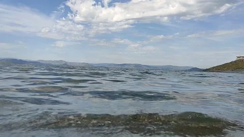Clear water. Mountains in the distance. Clouds. The splash of water. Stock Footage 335458692