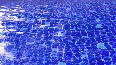 The clear water in the pool glistens in the sun and sways in the wind. Water Stock Footage 150592245