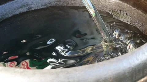Clear Water Pouring into Large Rustic Clay Pot Video stock 343587726