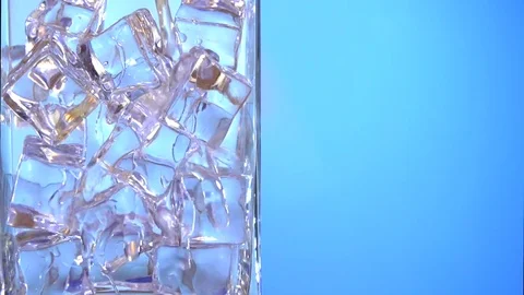 Clear water pours ice cubes on a blue  background. Video stock 75481071