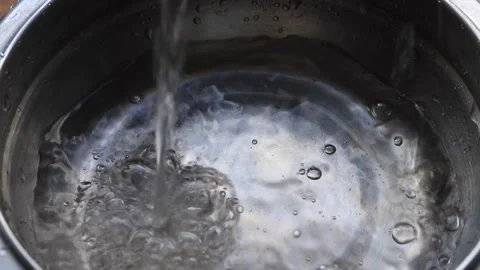 Clear water pours into a metal basin. Water being poured Stock Footage 340141908
