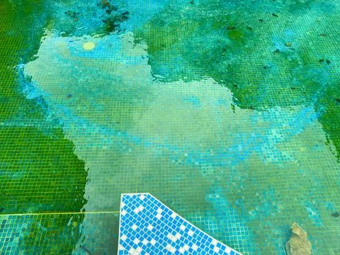 Clear water reflects blue tiles in a swimming pool during a sunny day in a .. Stock Photos
