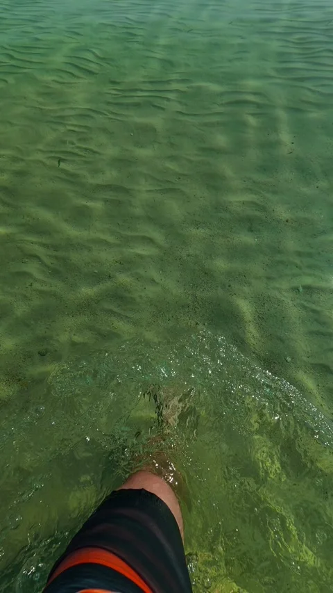Clear water ripples around bare feet. Trani Ammouda, Greece. Vertical Stock Footage 338358269