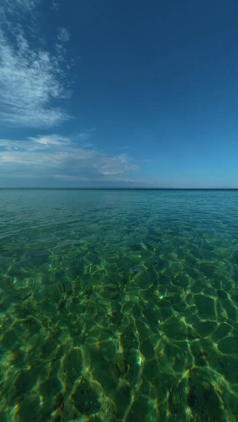 Clear water ripples beneath a deep blue sky. Nikiti, Greece. Vertical Stock-Footage 339025685