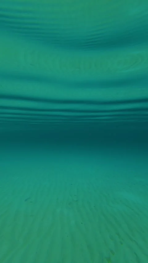 Clear water ripples gently beneath a vast blue sky. Trani Ammouda, Vertical Stock Footage 340650435