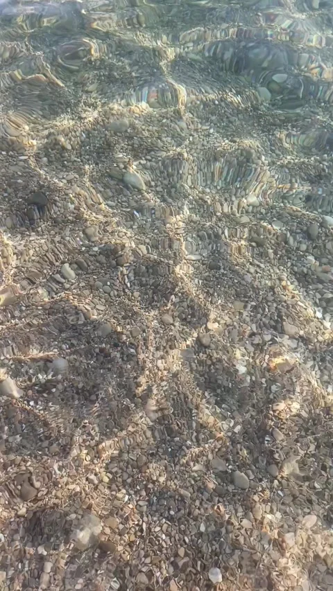 Clear water ripples over pebbles at Cap d’Ail on the French Riviera,  Stock Footage 342558878
