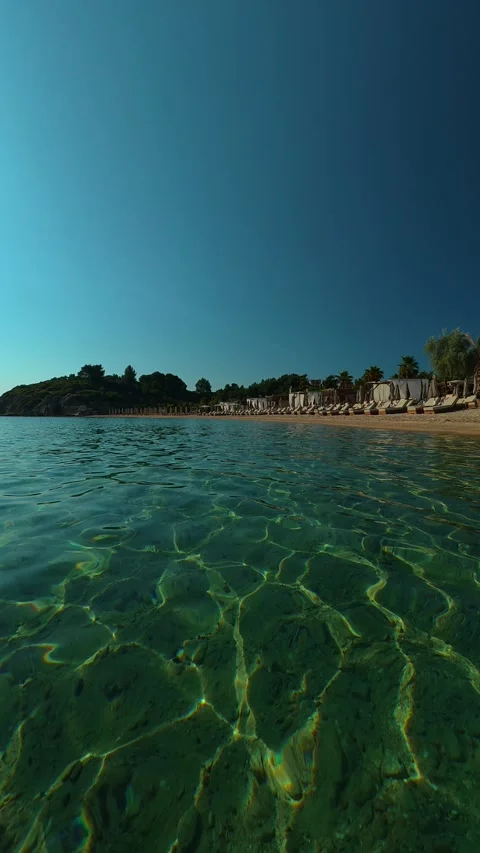 Clear water ripples under sunlit sky. Trani Ammouda, Greece. Vertical Stock Footage 338358309