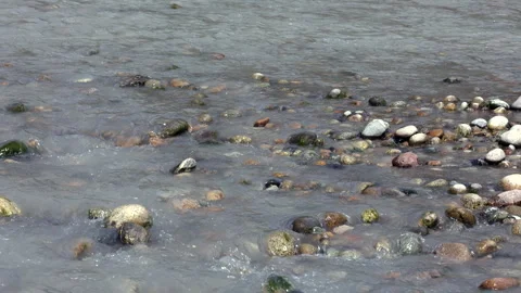 Clear Water Of A Shallow Stream Or River Flows Gently Over Smooth, Rounded Rocks Stock Footage 315766758