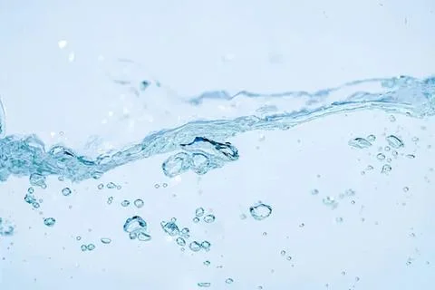 Clear water splash with bubbles and ripples on blue background Foto stock