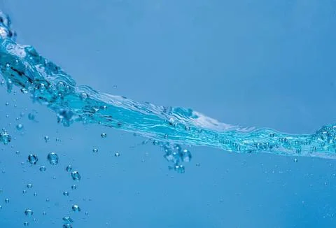 Clear water splash with bubbles in blue liquid Stock-Fotos
