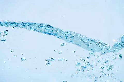 Clear water splash with bubbles in blue liquid Stock Photos