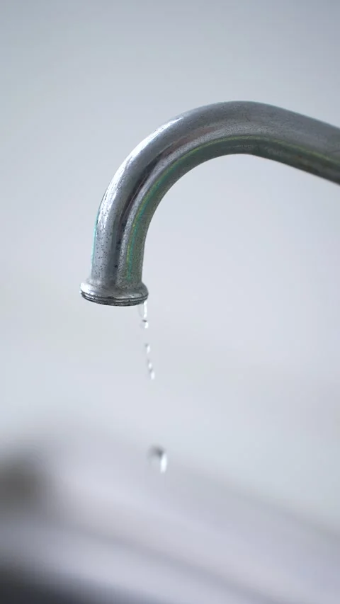 Clear water streaming smoothly from a metal faucet Stock Footage 344704527