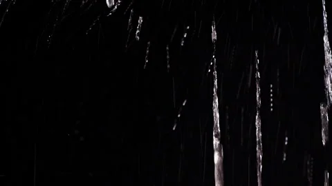 Clear Water Streams And Droplets Fall Against a Black Background, Creating a Dar Stock Footage 341422815