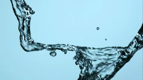 Clear water streams splash and mix together against a blue background Stock Footage 326629146