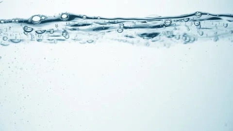 Clear water surface in slow motion, air bubbles, drop splashes and ripples after Stock Footage