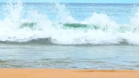Clear water waves break on the sandy beach under a blue sky. Video stock 308054776