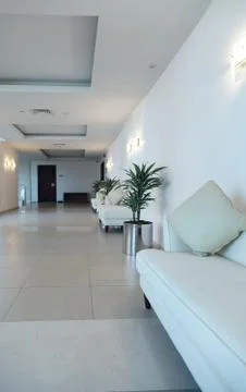 Clear white corridor interior. white leather sofas by the walls. Stock Photos