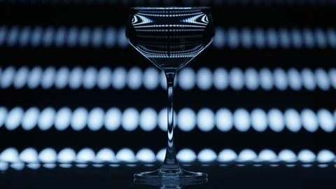 Clear wine glass standing infront of a falling dotted pattern in the background Stock Footage 237169541
