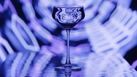 The clear wine glass stands infront of blue hexagonal tube patterns. Stock Footage 237168819
