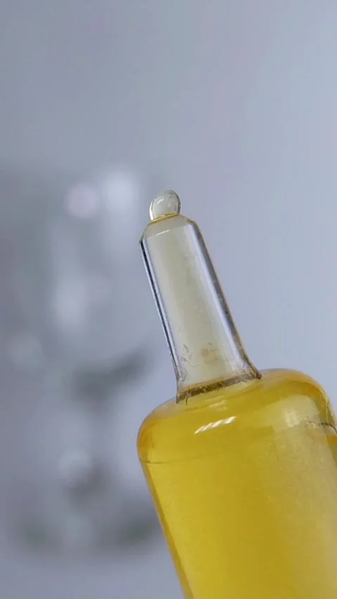 Clear yellow liquid slowly coming out from a transparent syringe. Beauty se.. Stock Footage 340511366