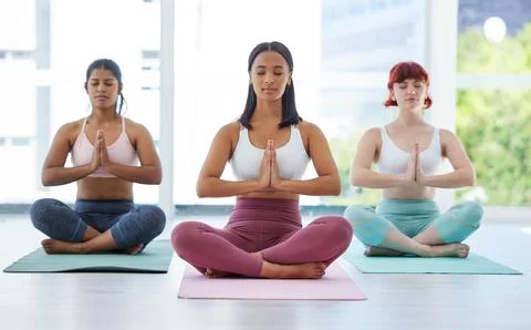 Clear your mind, transform your body. a group of sporty young women meditating Stock Photos