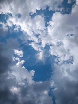 Clearance of the blue sky between dense clouds. Scenic view of beautiful clouds. Stock Photos
