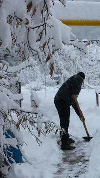 Clearing the area of ​​snow during a snowfall Stock Photos