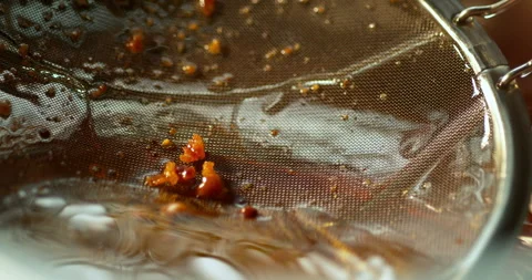 Clearing the bits and filtering the fryer in slow motion Stock Footage 310528177