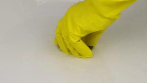 Clearing a clogged bathtub drain using a plunger, with hands protected by gloves Video stock 327375241