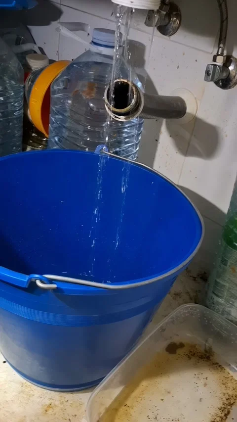 Clearing clogged kitchen sink drain and draining water into bucket Stock Footage 337344978