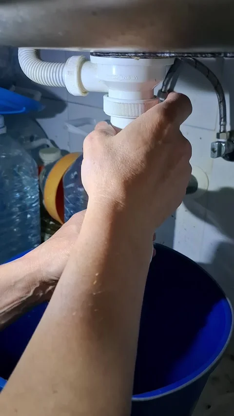 Clearing a clogged kitchen sink drain and assembling the drain pipe step by.. Stock Footage 337345047