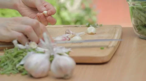 Clearing from dry husks every single clove of garlic outdoors Stock Footage 8367651