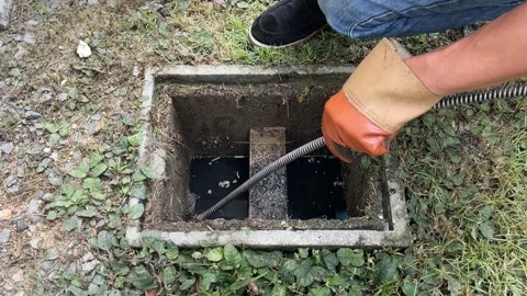 Clearing an outside drain blocked with fat. Stock Footage 225699292